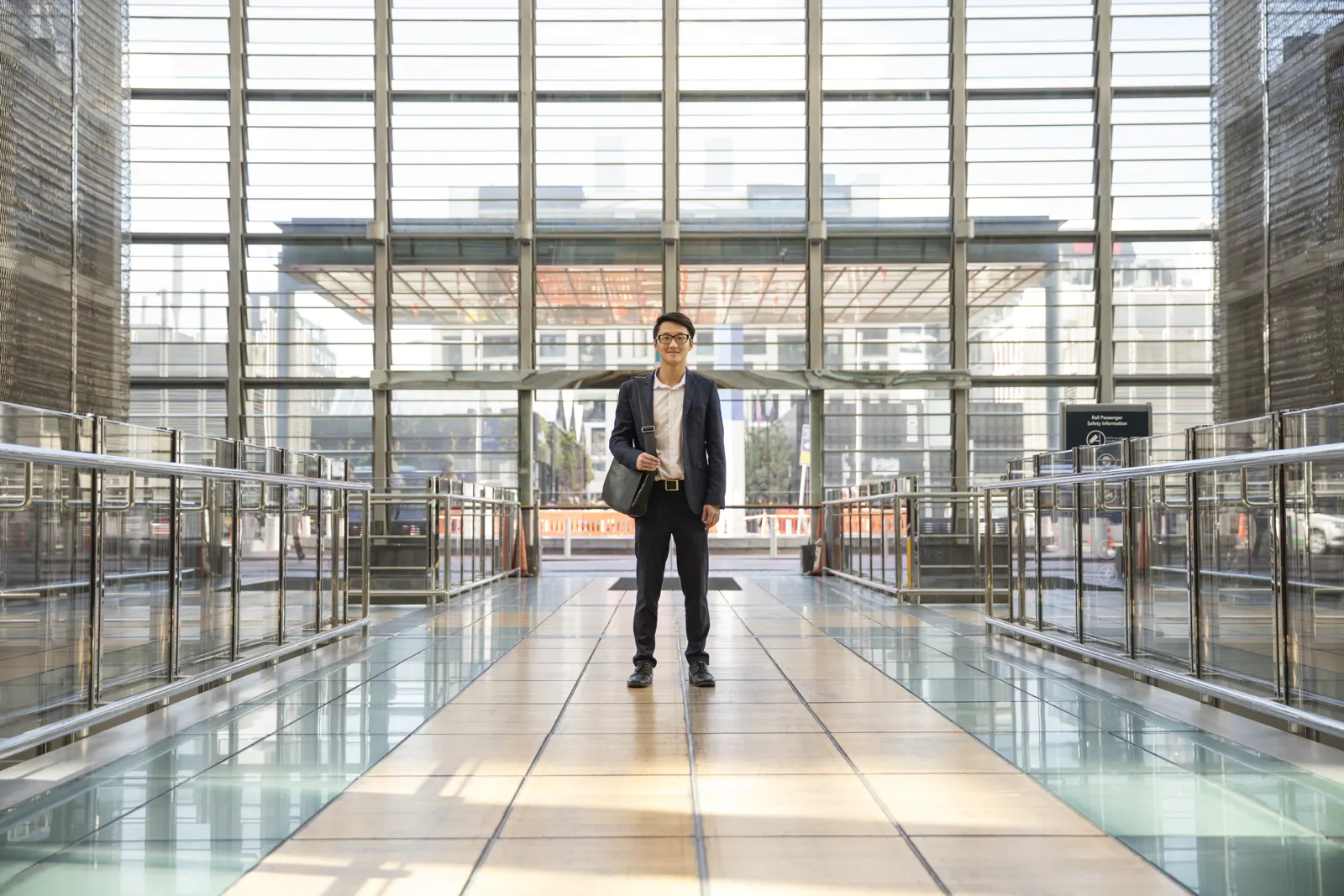 Student standing in a modern glass building in Auckland
